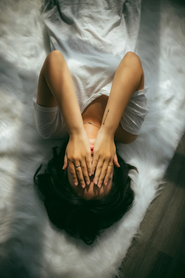 Woman covering her face as she struggles and needs counselling in Farnham